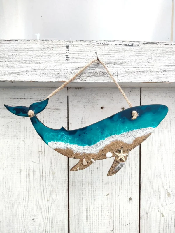 Ballena decorativa de madera y resina colgada de una cuerda