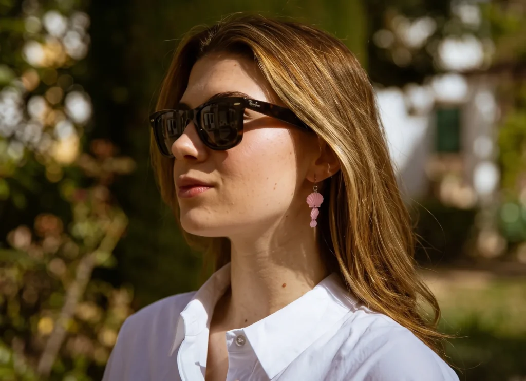 Mujer con gafas de sol y pendientes Shell rosas